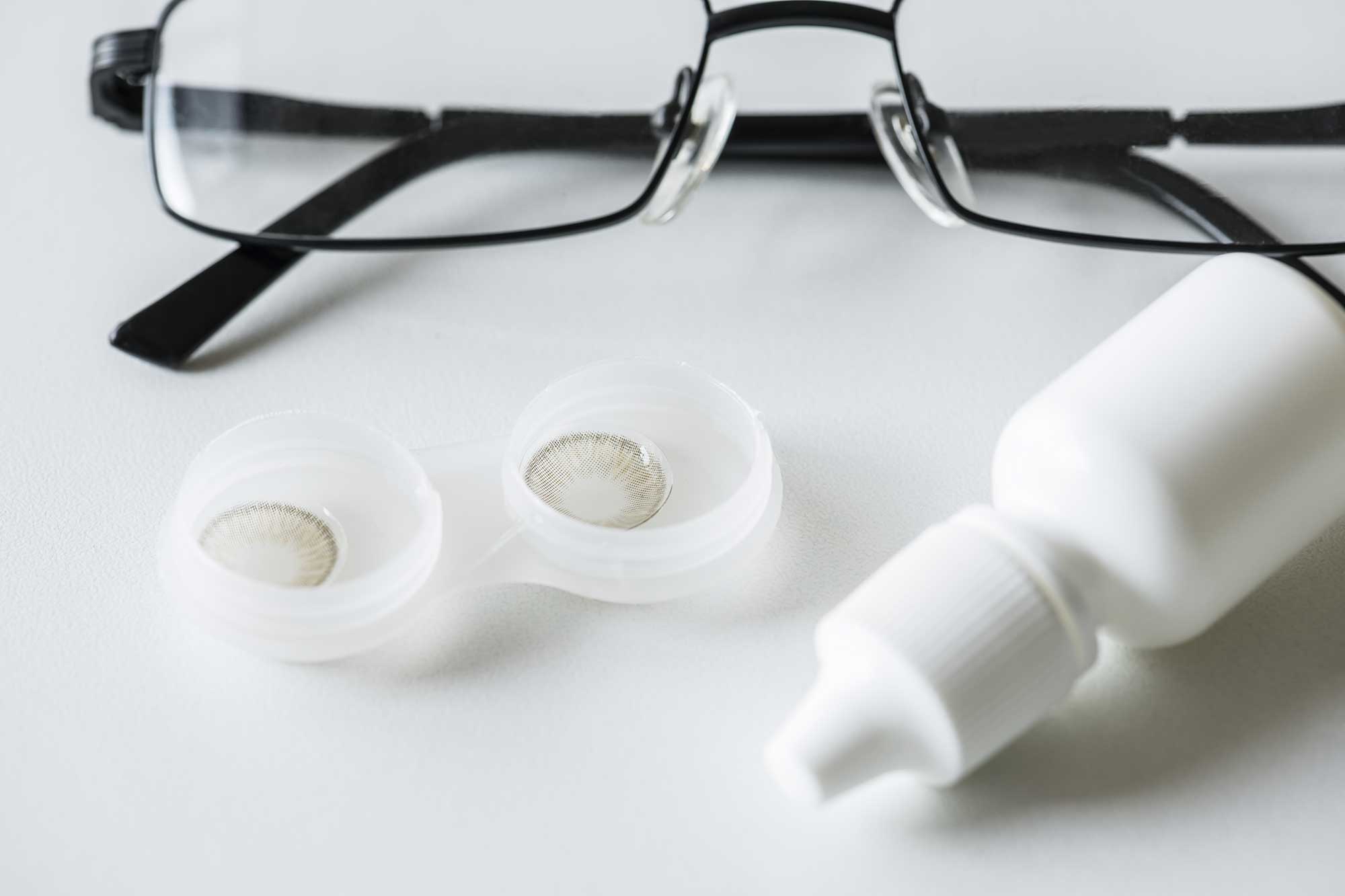 Glasses and contact lenses arranged neatly on a table, showcasing options for vision correction.